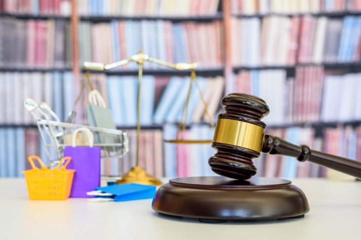 Consumer protection law, rights and guarantees, justice concept : Judge gavel, balance scale, bags, a shopping cart, depicting a safeguard designed to protect buyers from fraudulent business practices