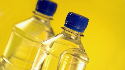 wo plastic bottles of water against a yellow backdrop, illustrating food contact migration testing